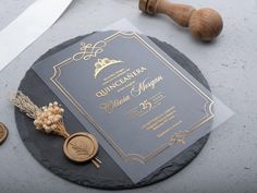 an elegant wedding card on a slate slab next to a knife and some gold coins