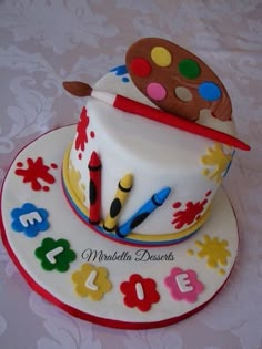 a birthday cake decorated with paintbrushes and numbers