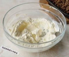 a bowl filled with whipped cream next to a cookie sheet