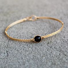 So simple and feminine, this is a thin bangle of three strands of 14kt gold filled wire, with a single 6mm gemstone bead of your choice as the centerpiece. Choose from amethyst, garnet, rose quartz, hematite, lapis lazuli, black onyx, or tiger eye. All are genuine smooth, polished gemstone beads. Choose your size for a perfect custom fit. Plain Gold Bangles, Modern Gold Jewelry, Gold Jewelry Simple Necklace, Black Beaded Bracelets, Silver Bracelets For Women, Bracelet Simple, Jewelry Bracelets Gold, Antique Gold Jewelry, Gold Rings Fashion