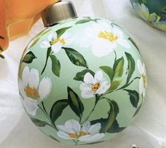 an ornament with flowers painted on it next to other ornaments and decor items