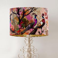 a table lamp with a colorful bird design on the lampshade next to it