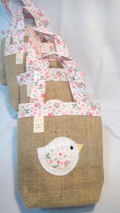 three bags with bird appliqued on them sitting next to eachother