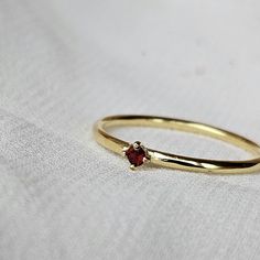 Description: This delicate and refined ring features a tiny 2mm AAA Garnet gemstone set in 925 sterling silver with the option of gold plating.  This ring is perfect for stacking or wearing solo to add a subtle touch of style.  Care Tips for the Gold plated Version: This ring is gold-plated, so it needs a little extra love to keep it looking great. Here's how to make it last: Avoid harsh chemicals: Keep your ring away from perfumes, lotions, and cleaning products, as they can wear off the gold p 14k Gold Gemstone Midi Rings Gift, Dainty Round Ruby Promise Ring, Gemstone Midi Rings For Anniversary, Dainty Gemstone Midi Rings With Round Band, Ruby Stackable Rings With Birthstones, Dainty Stackable Ruby Ring For Promise, Tiny Round Birthstone Ring For Anniversary, Dainty Ruby Ring With Birthstone, Dainty Ruby Promise Ring