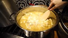 a person stirring food in a pot on the stove