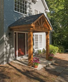 a house with a wooden porch and covered patio area next to the front door is shown