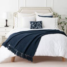 a bed with blue and white pillows on it