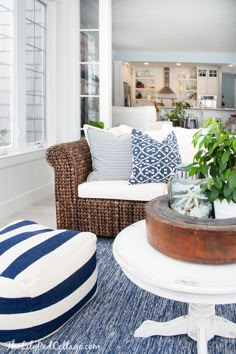 a living room filled with lots of furniture and decor on top of a blue rug