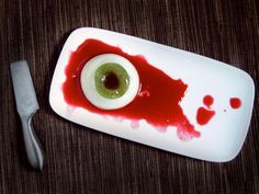 an eyeball is placed on a plate with a knife