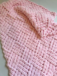 a pink cloth is laying on top of a white table and it looks like woven fabric