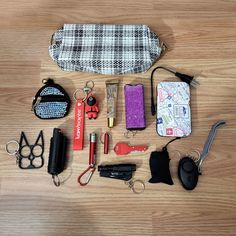 an assortment of personal items laid out on a wooden surface with scissors, keys and other accessories