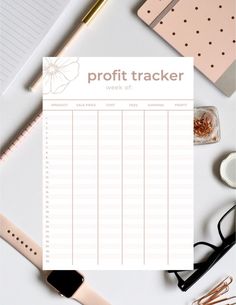 a white desk topped with lots of office supplies and a paper that says profits tracker