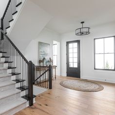 a staircase leading up to the second floor in a home with hardwood floors and white walls