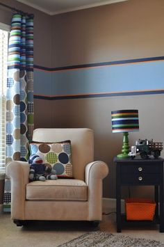 a living room with a chair and lamp on the side table next to a window