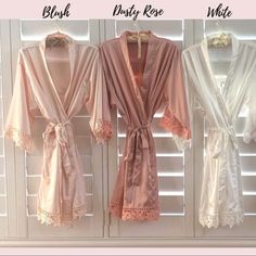 three robes hanging on the wall next to each other in front of white shutters