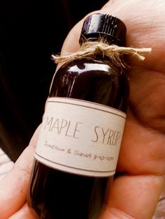 a bottle of maple syrup is held in someone's hand with the label on it