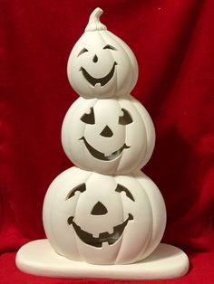 three carved pumpkins stacked on top of each other