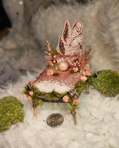 a miniature chair with flowers and leaves on it's back sitting on some white fur