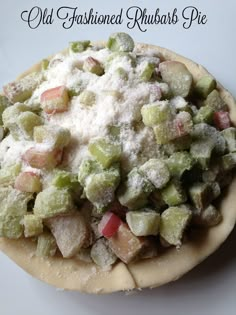 an old fashioned rhubarb pie is topped with powdered sugar and chopped fruit