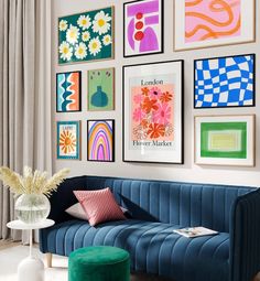 a living room filled with lots of art on the wall above a blue velvet couch