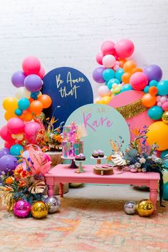 an assortment of colorful balloons and decorations on a table with a sign that says, you are kare