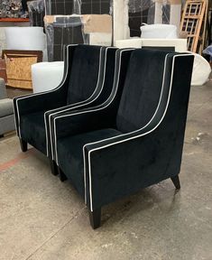 three black and white chairs sitting in a room with boxes on the floor behind them