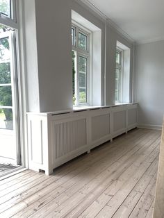 an empty room with wooden floors and windows