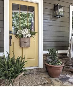 a yellow door and some plants on the front porch