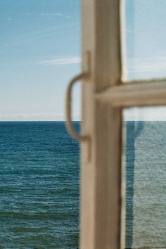 an open window looking out at the ocean