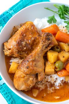 a white bowl filled with rice, meat and veggies next to garnish