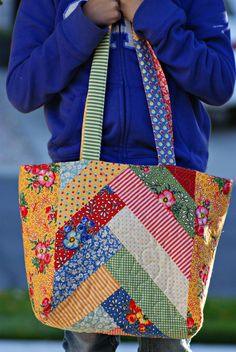 a woman carrying a multicolored patchwork tote bag