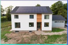 a white house with solar panels on the roof