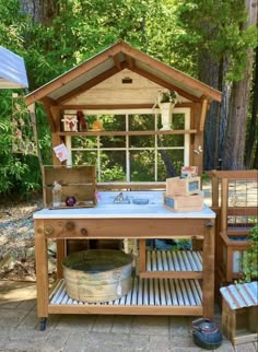 an outdoor kitchen made out of pallets in the woods, with a sink and window