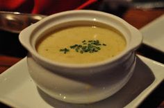 a white bowl filled with soup on top of a plate