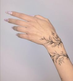 a woman's hand with a black and white flower tattoo on the left wrist