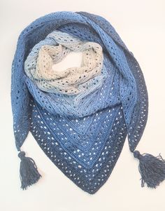 a crocheted scarf with tassels on it