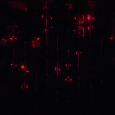 red lights are shining in the dark and blurry pattern on the wall behind them