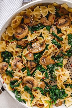 pasta with mushrooms and spinach in a white bowl