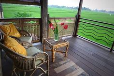 two wicker chairs sitting on top of a wooden porch