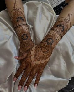 two hands with henna tattoos on them