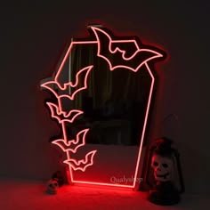 a lighted mirror with bats on it and a skull in the corner next to it