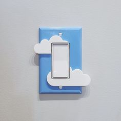 a blue and white light switch sitting on top of a wall next to a cloud