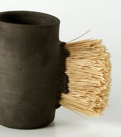 a close up of a cup with a brush sticking out of the inside of it