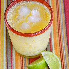 a drink in a glass with ice and lime