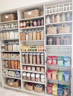 an organized pantry with lots of food and baskets on the shelves in front of it