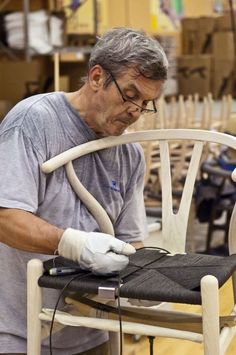 a man working on a chair in a shop