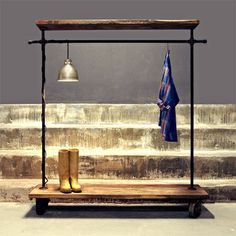 a pair of boots sitting on top of a wooden bench next to a metal bell