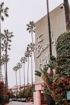 the sign for the beverly hotel is surrounded by palm trees