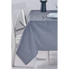 a black and white checkered tablecloth with a vase on it next to a chair