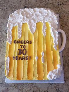 a cake that has been decorated with yellow and white frosting on the top, says cheers to 30 years